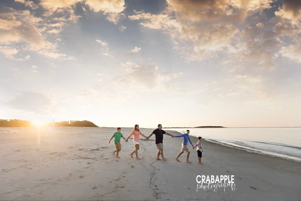 Family walking hand-in-hand along the sand at sunset on Crane Beach