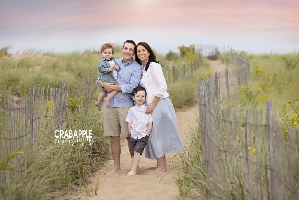 Family walking down dune path at Plum Island during golden hour
