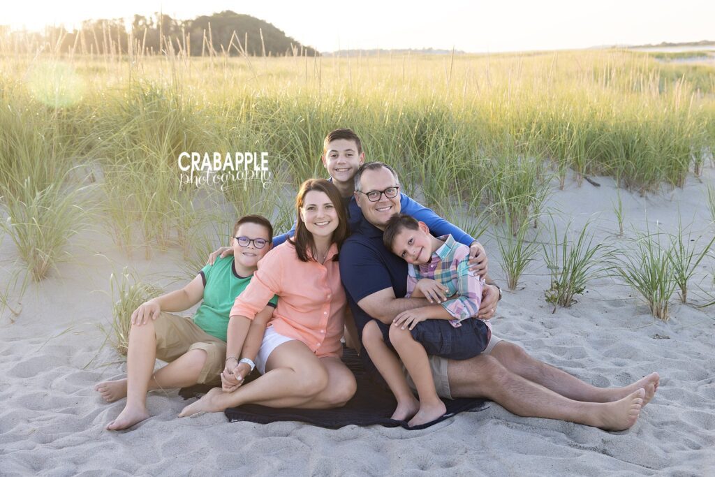Family sitting together in dune grass during Crane Beach sunset session