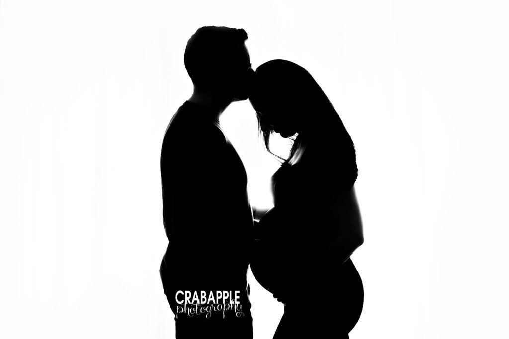 High-contrast silhouette photo of couple kissing during maternity session – Experienced Maternity Photographer