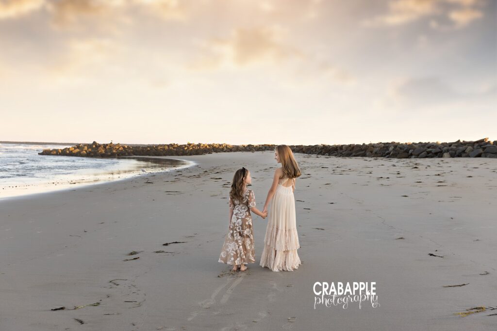 Sisters walking barefoot along the shoreline