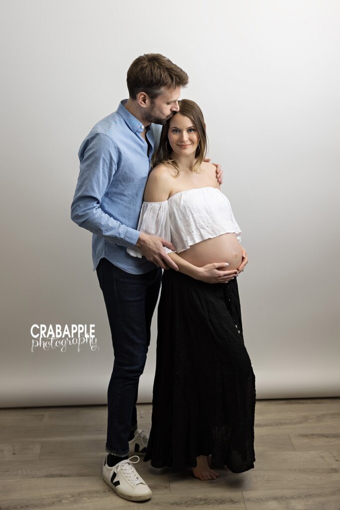 Relaxed in-studio maternity pose with partner holding mom-to-be – Experienced Maternity Photographer Andover MA