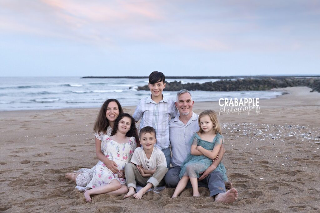 Big family photo during a Salisbury Beach family session Large family smiling on the beach, captured by a Massachusetts beach photographer