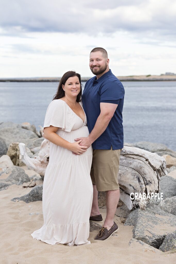 Expecting couple embracing during beach maternity session in Boston MA