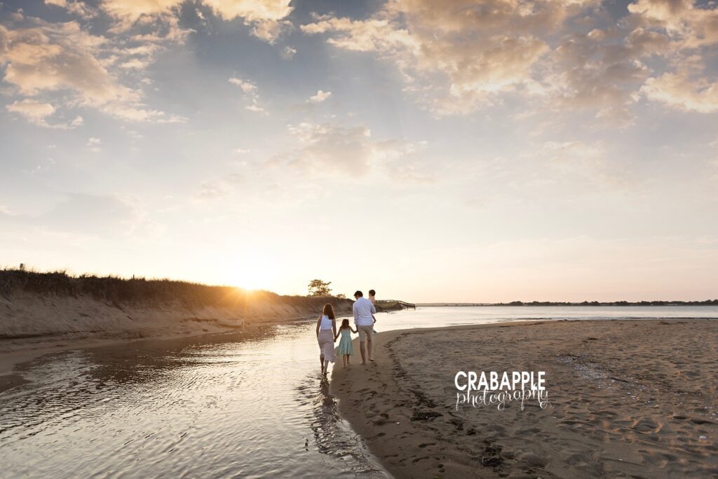 Golden hour beach portrait of family of four from Cambridge MA walking along the water away from camera