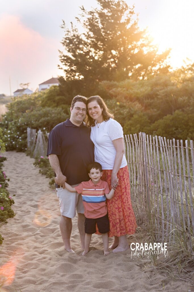 Family of three walking to Salisbury Beach at sunset during mini session