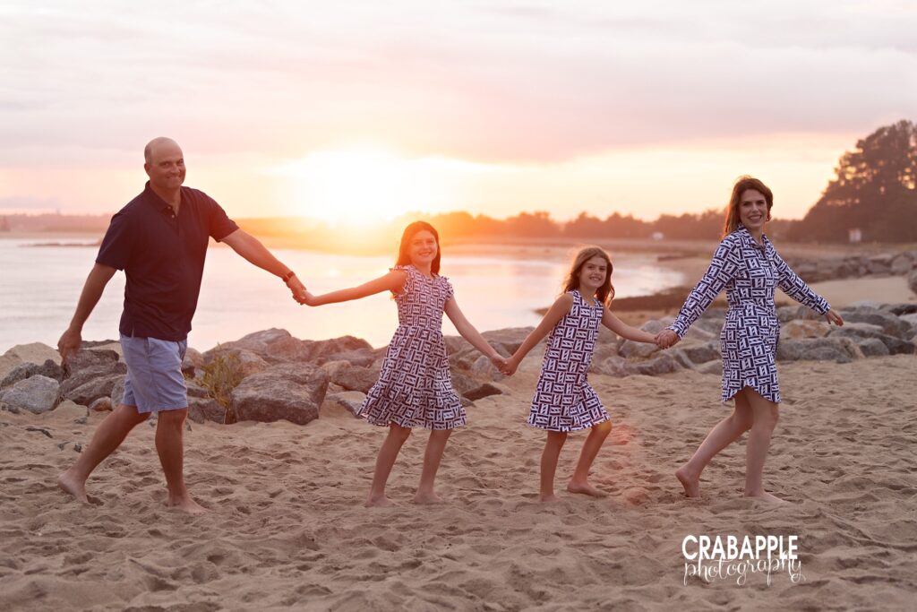Sunset casts a beautiful glow over family of four during beach photos