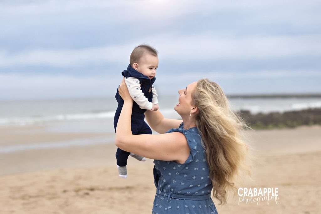 Photo of mom holding baby sun up during a beach mini session north of Boston
