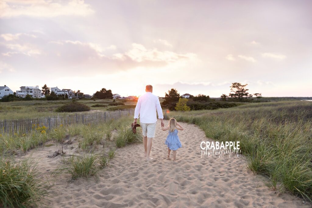 Sunset beach photo of father and daughter Stunning sunset beach photo featuring father and daughter walking hand in hand