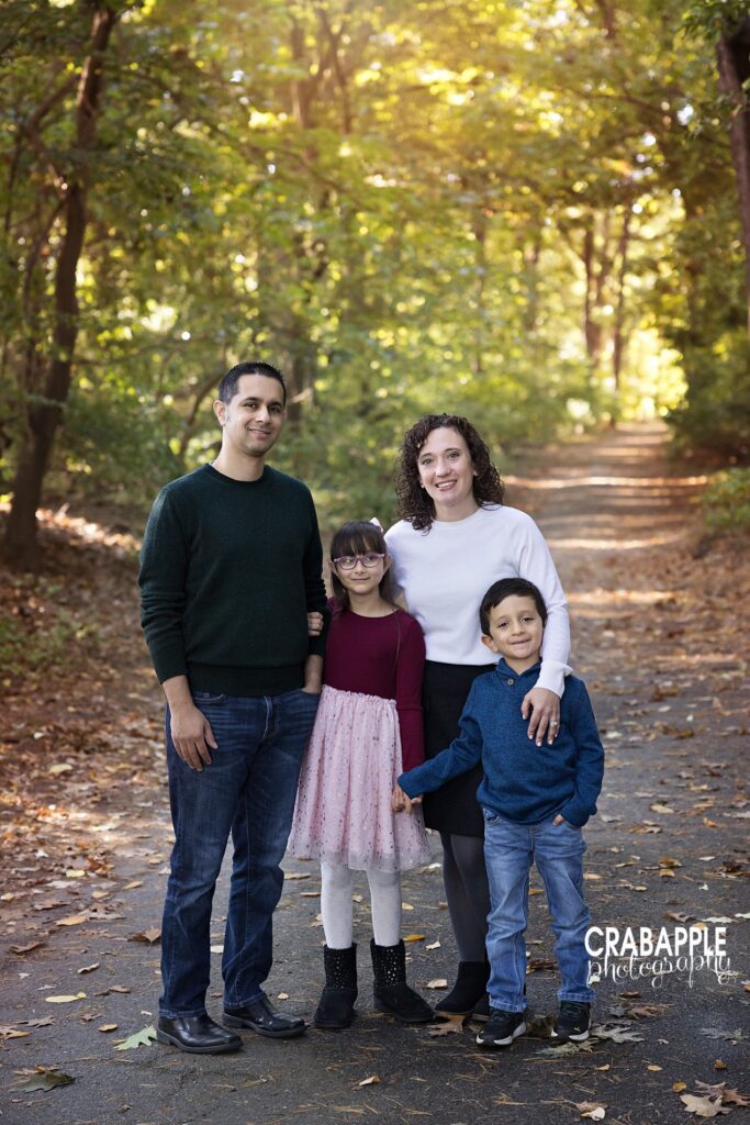 A family poses for fall photos in various shades of rich jewel tones