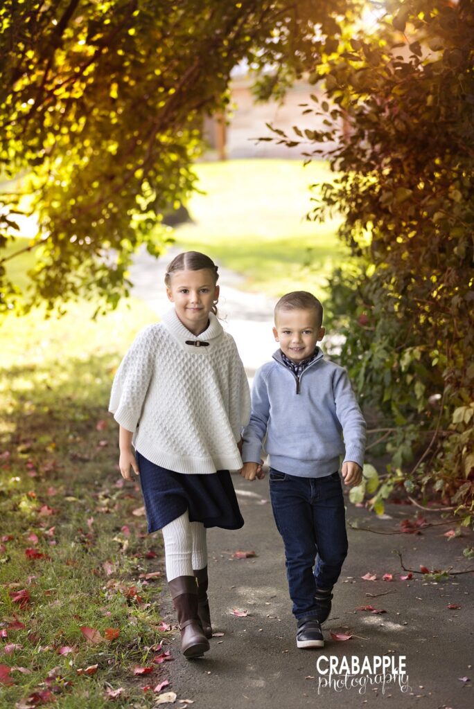 Best colors for fall family photos featuring siblings Brother and sister holding hands in timeless and neutral fall family photo outfits