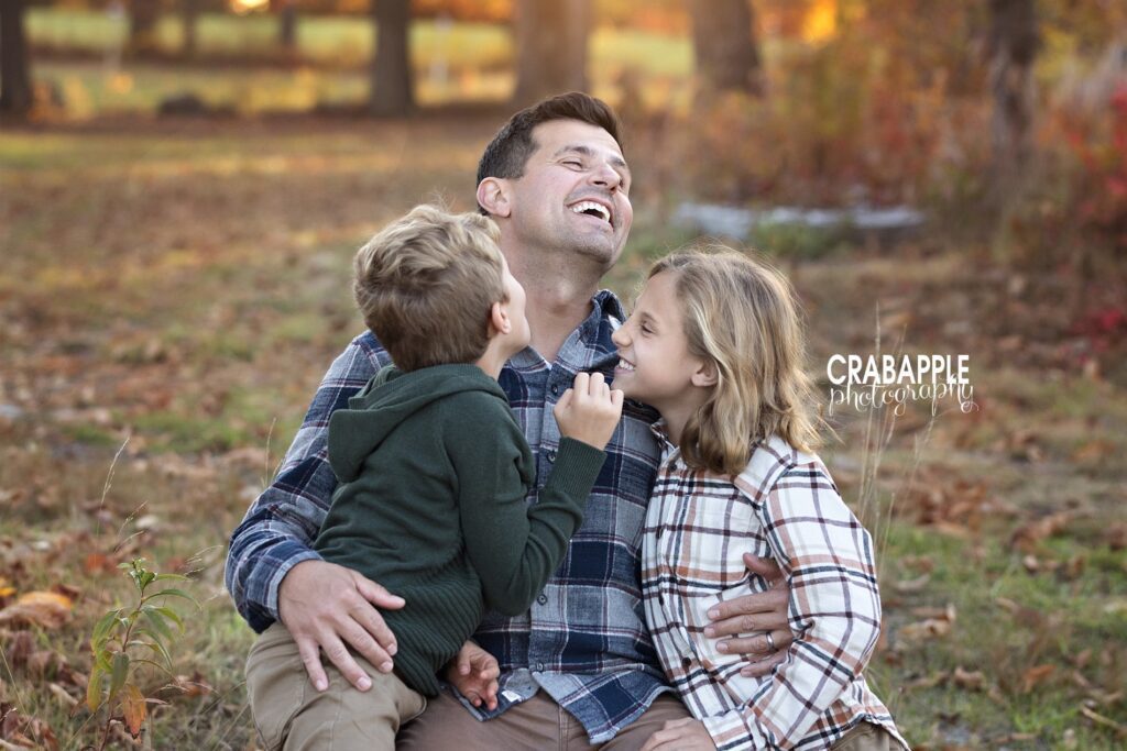 A candid photo of a father and his two sons sharing a laugh and a hug during their family photo session near Somerville MA