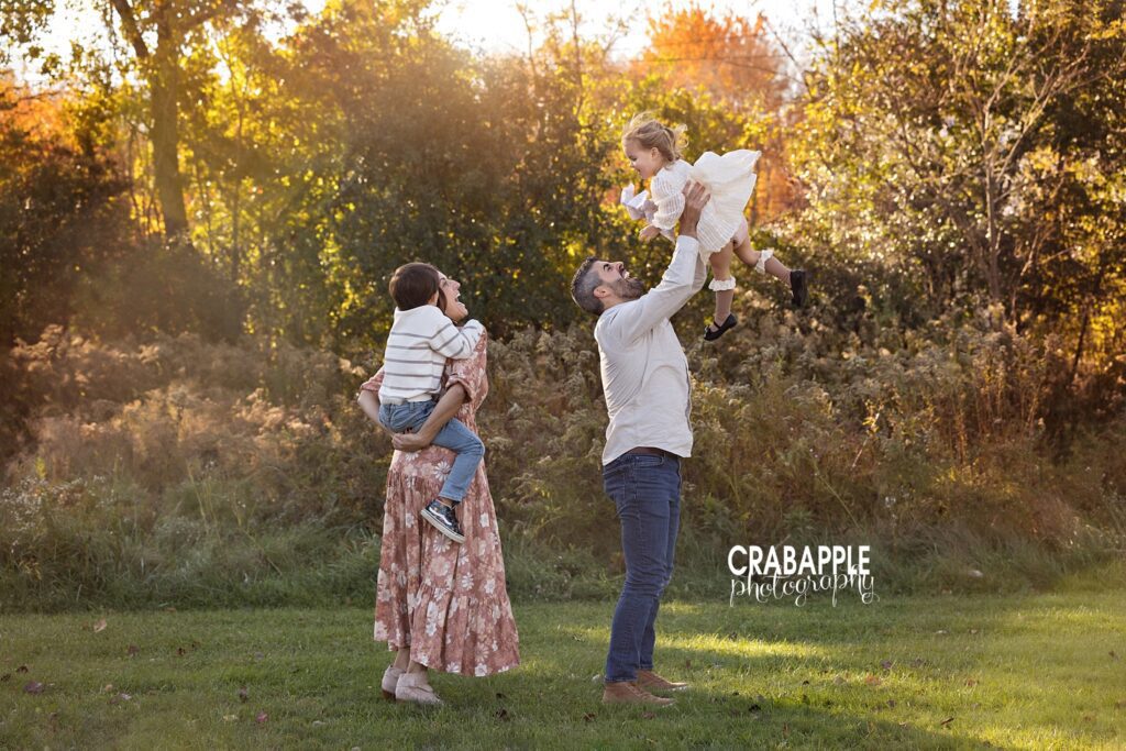 Fun ideas for sweet family portraits Fun candid moment captured during family portrait session with dad lifting toddler daughter up in the air