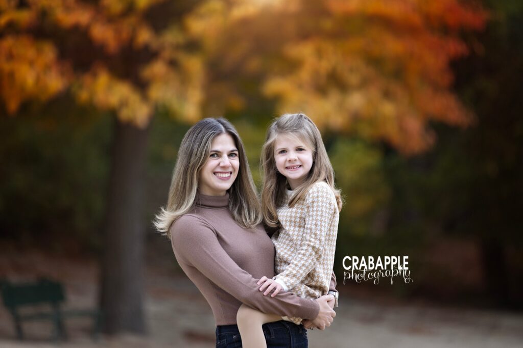A mother and daughter pose for fall  family photos using shades of brown and tan
