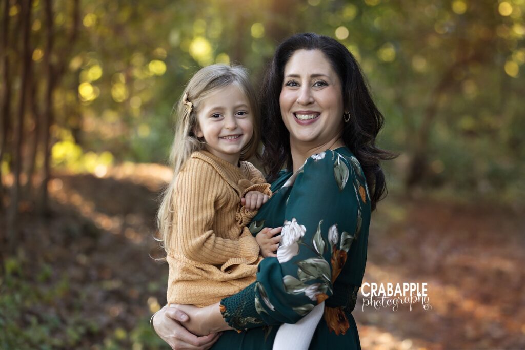Mother and daughter dressed in coordinating shades of emerald and goldenrod for their fall photos
