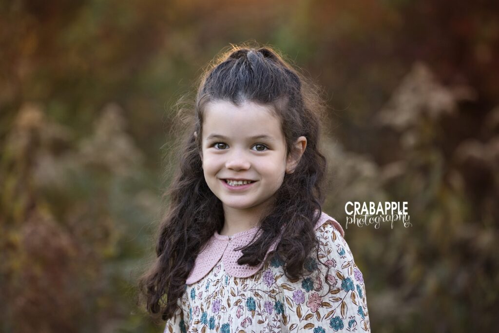 Solo portrait of older daughter in Andover fall family photos Older daughter smiling in solo portrait during fall family photos in Andover MA