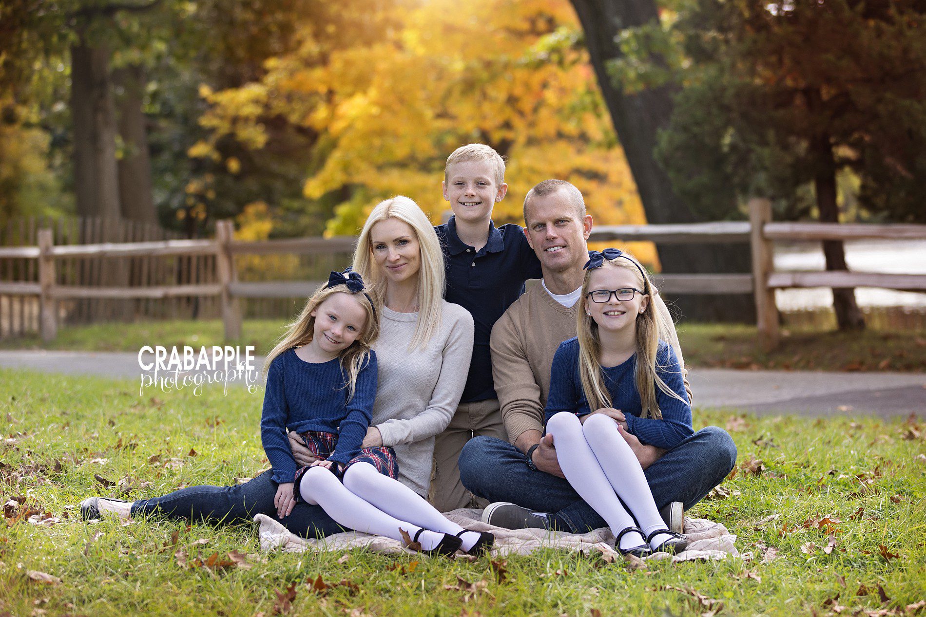 Family sitting on a blanket during outdoor fall family photos in Boston
