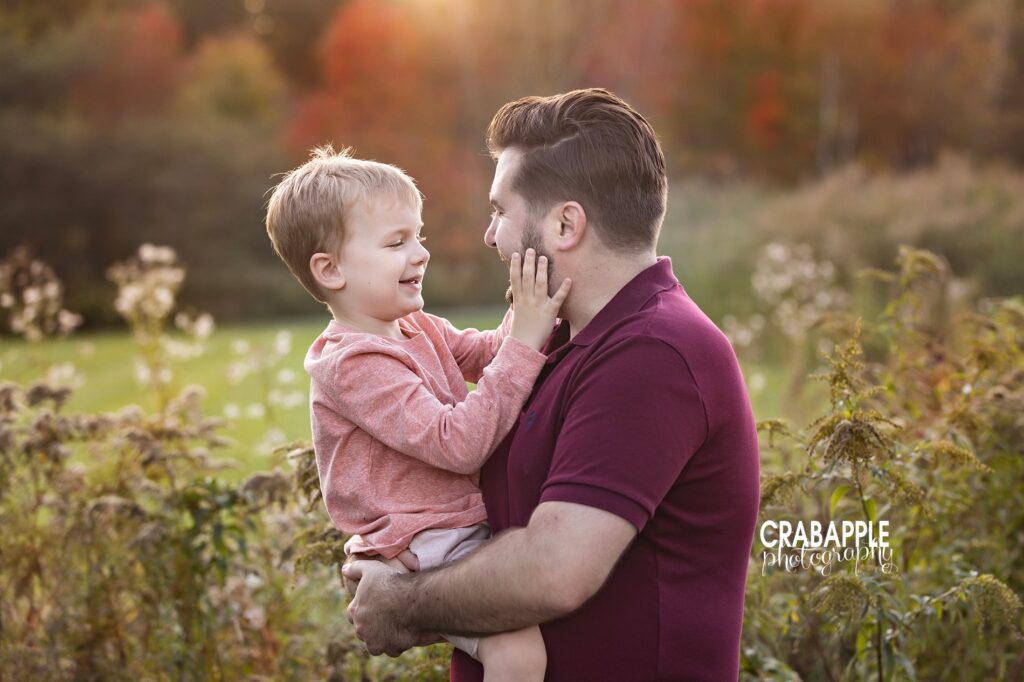 Father and son portrait ideas Candid photo of a father and 5 year old son sharing a sweet moment together during family portrait session near Needham MA