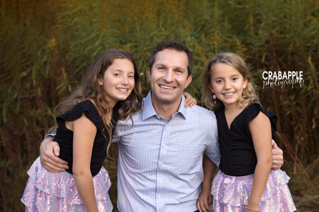 A father poses with his two daughters during family photos