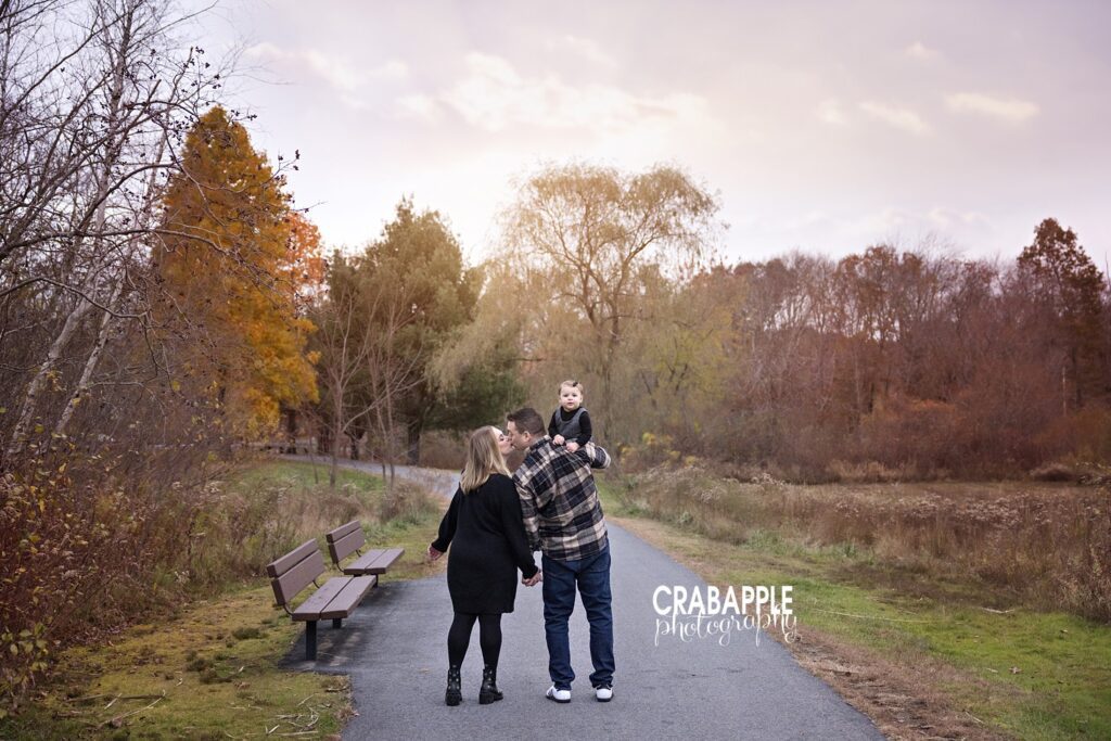 North Reading family photographer fall portraits Family walking together through North Reading park in autumn
