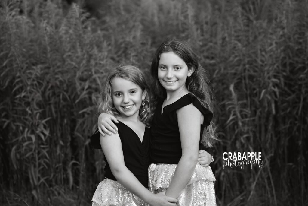 Black and white photo of two sisters posing outside during fall