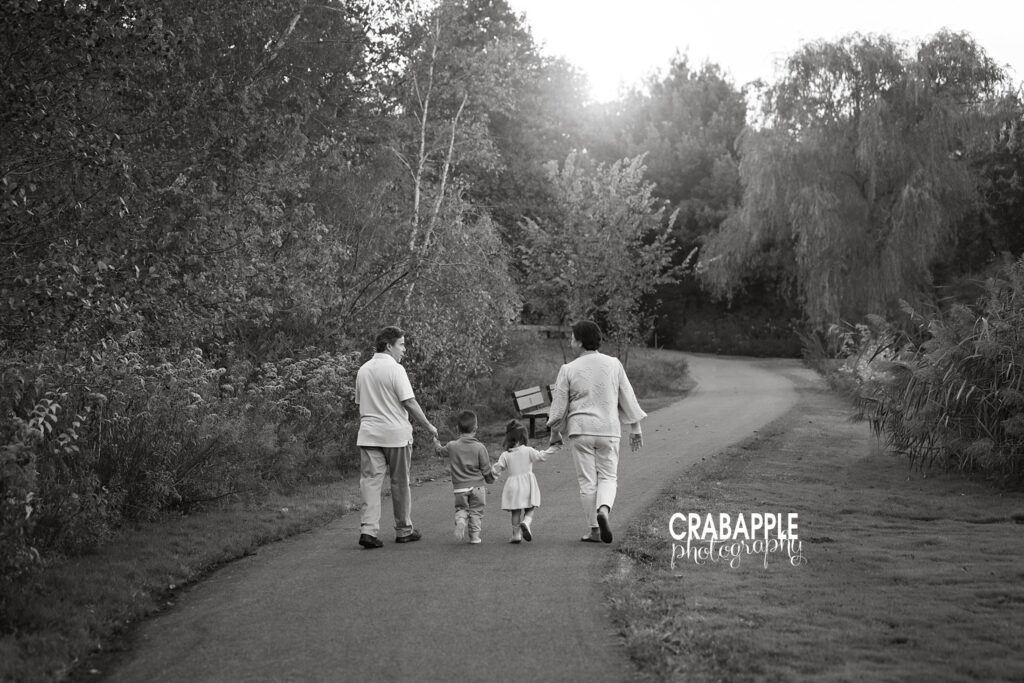 Family walking through a sunlit fall landscape in Andover MA.
