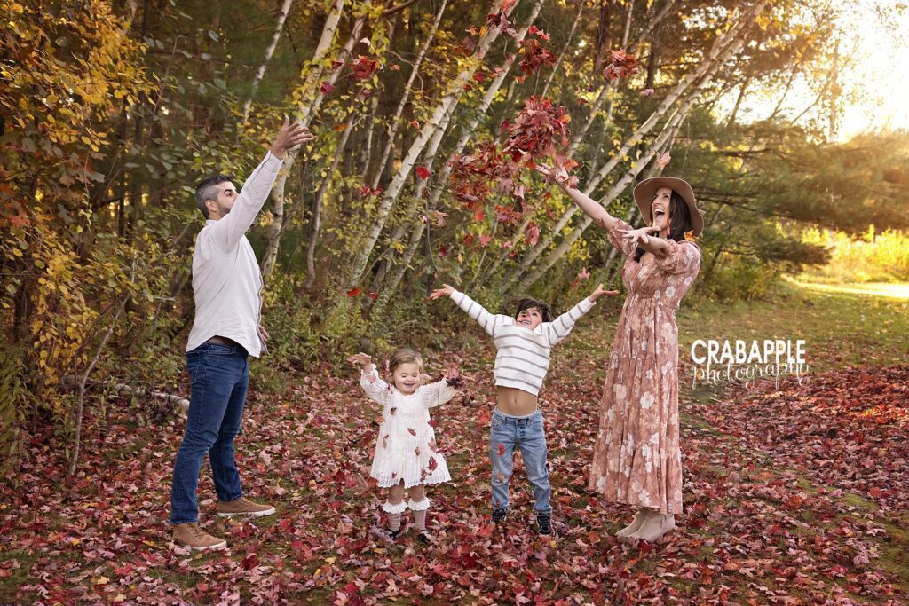 Candid fall family photos near Wakefield MA Fun playing in leaves family portrait during family photo session near Wakefield MA