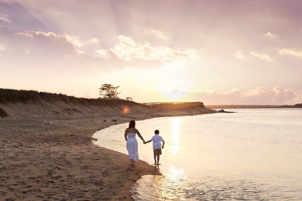 Mom walking with her little boy during golden hour beach photos
