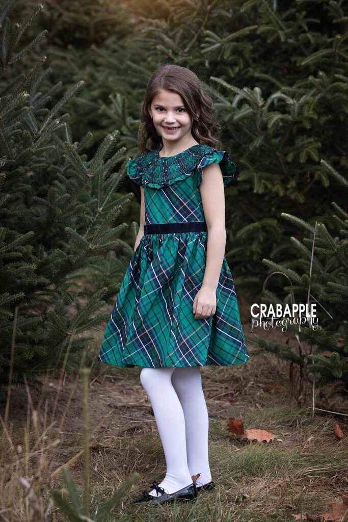 A young girl poses in a beautiful dress during outdoor tree farm photos
