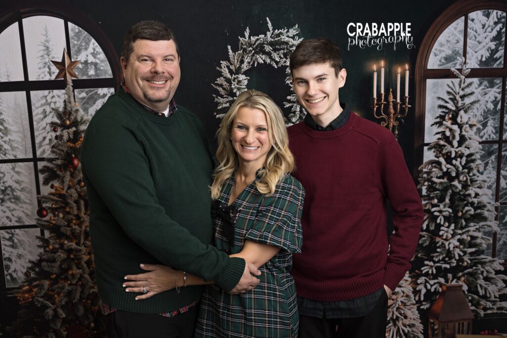 Mom, dad, and teenage son dressed formally for elegant Christmas portraits.
