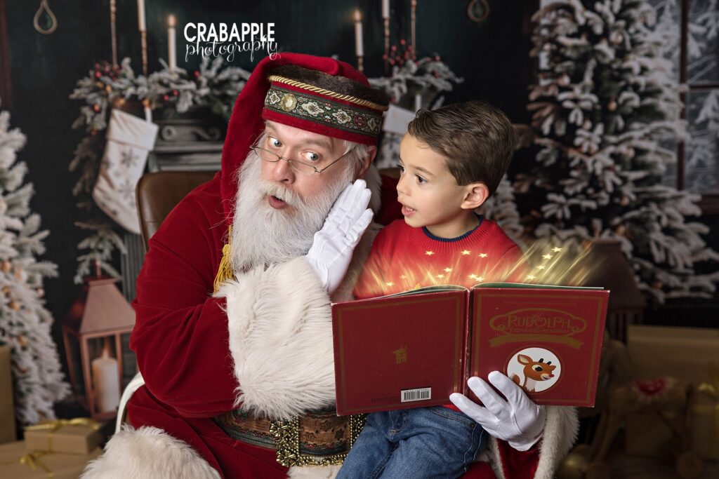 Toddler boy and Santa reading a book together during holiday mini session near Boston MA