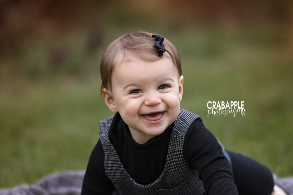 Baby girl smiling during solo child fall portraits in Massachusetts park

