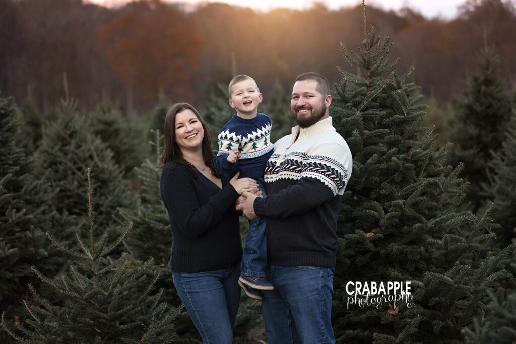 Family smiling together during tree farm mini session in Massachusetts
