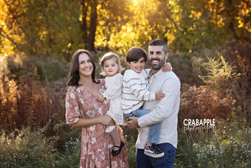 Family smiling during early fall park portraits in Massachusetts
