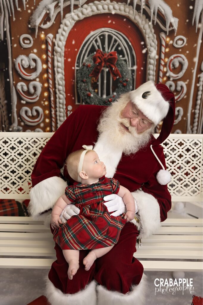 Portrait of Santa Claus and baby looking at one another during private Santa Claus portrait session in Andover MA