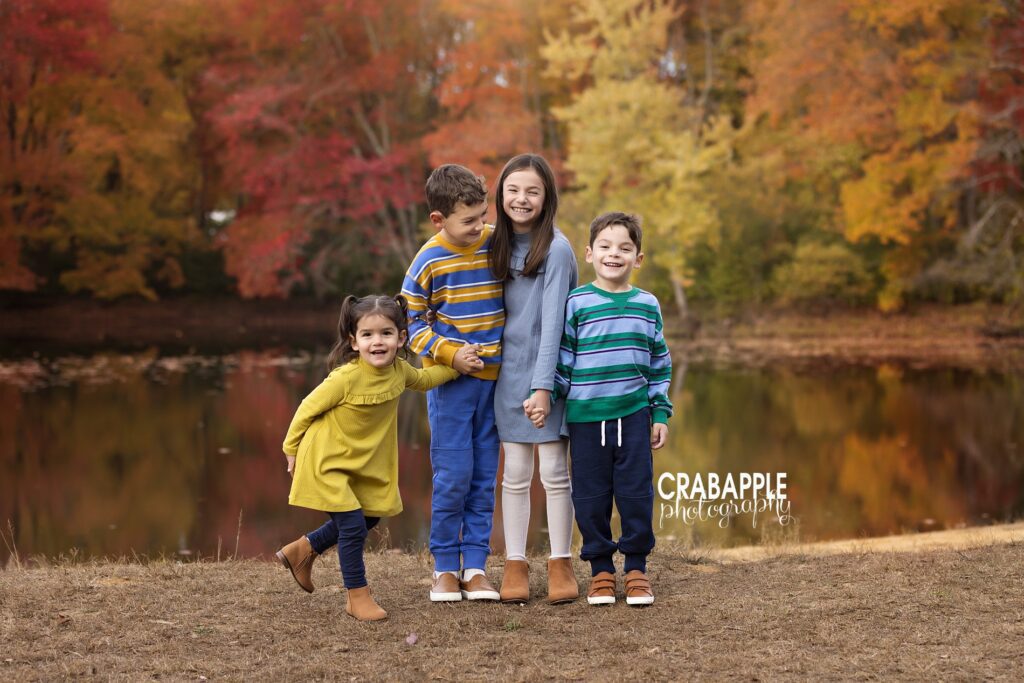 Siblings holding hands and laughing during fall park session near Boston
