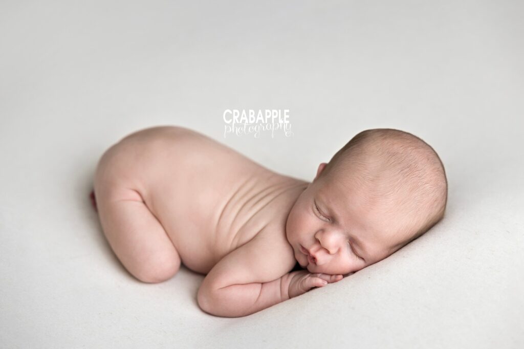 Newborn baby posed on white blanket in classic bum-up pose during Beverly MA studio newborn photography session