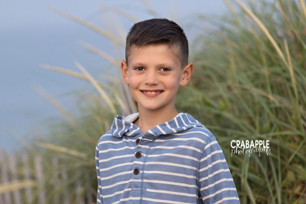 Young boy smiling near the water during North Shore MA beach photos
