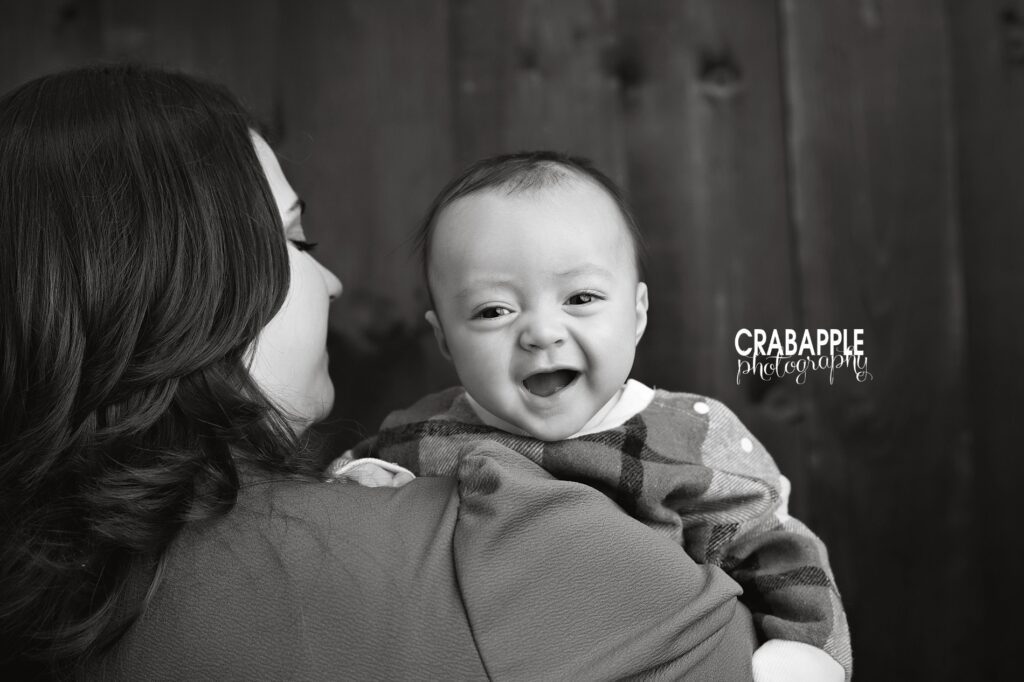 Tender indoor fall portrait of mom and baby in rustic studio. Tender moment between mom and baby during indoor fall studio session in black and white