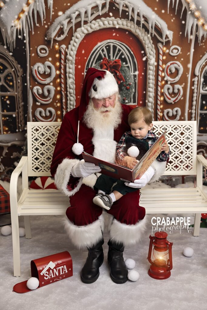 Santa reads a book to a toddler during Christmas portrait session in an Andover MA studio