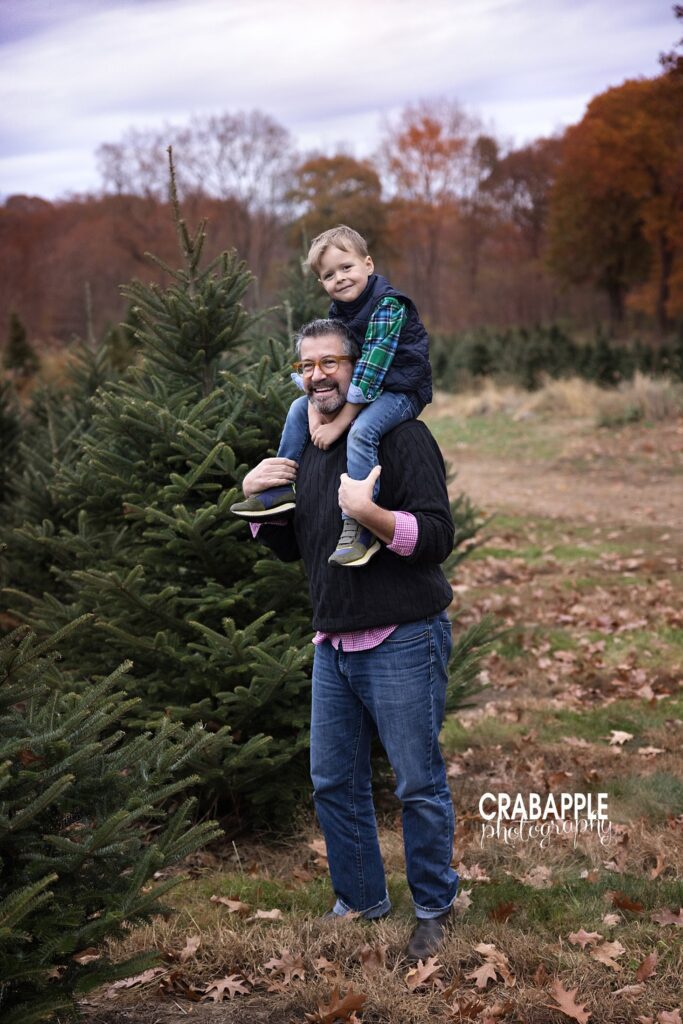 Dad gives son a shoulder ride during tree farm photos