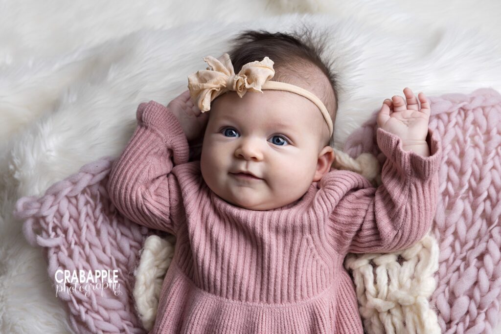 Baby girl in blush knit dress during professional baby photography session in Andover MA
