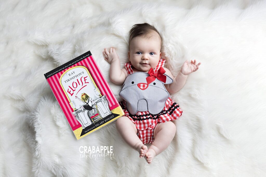 3-month-old baby girl milestone photos with book prop in professional Andover studio
