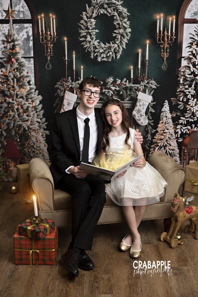 Two siblings styled in classic, formal outfits for Christmas portraits