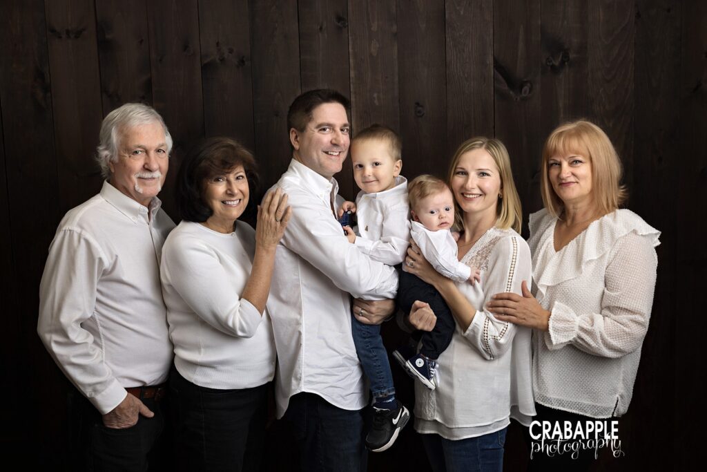 Full extended family newborn photo including parents grandparents and sibling
