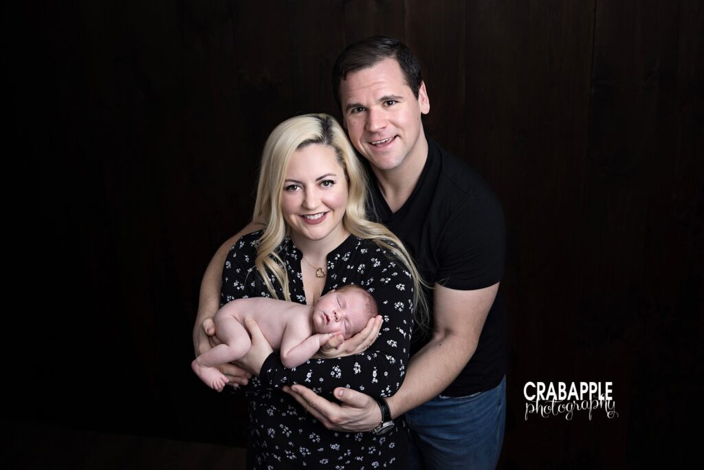 Mom and dad cuddling newborn baby during studio family photo session | North Shore MA newborn photos