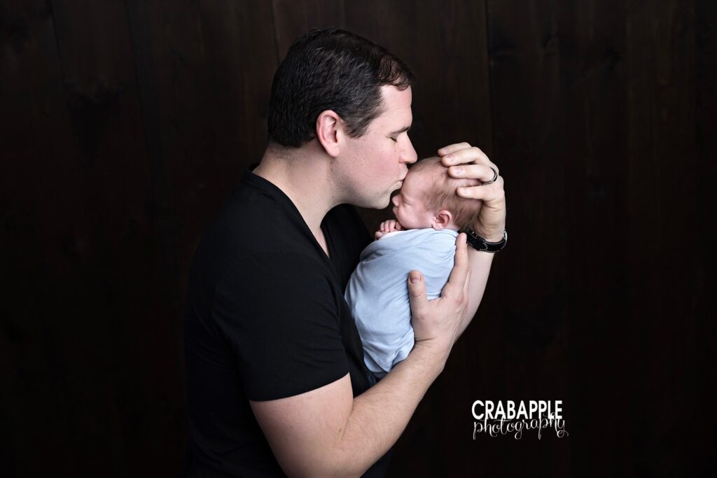 Proud dad kissing newborn during family newborn session | North Shore MA newborn photographer
