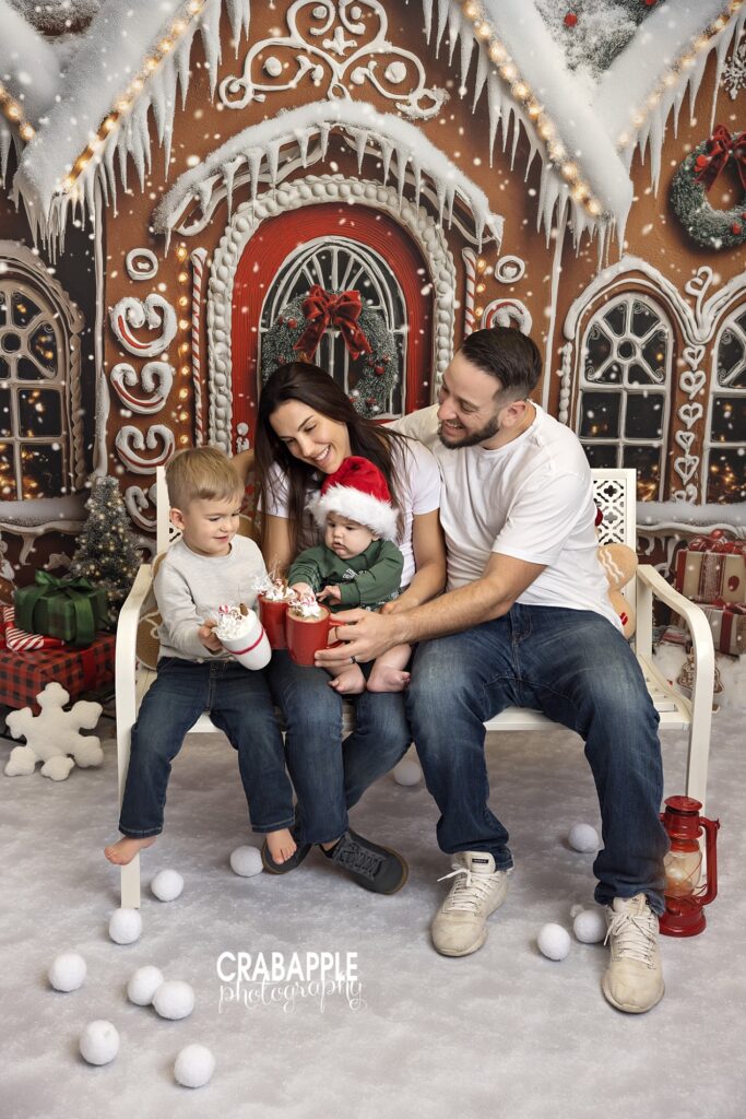Full family portrait in studio holiday setup with gingerbread backdrop.
