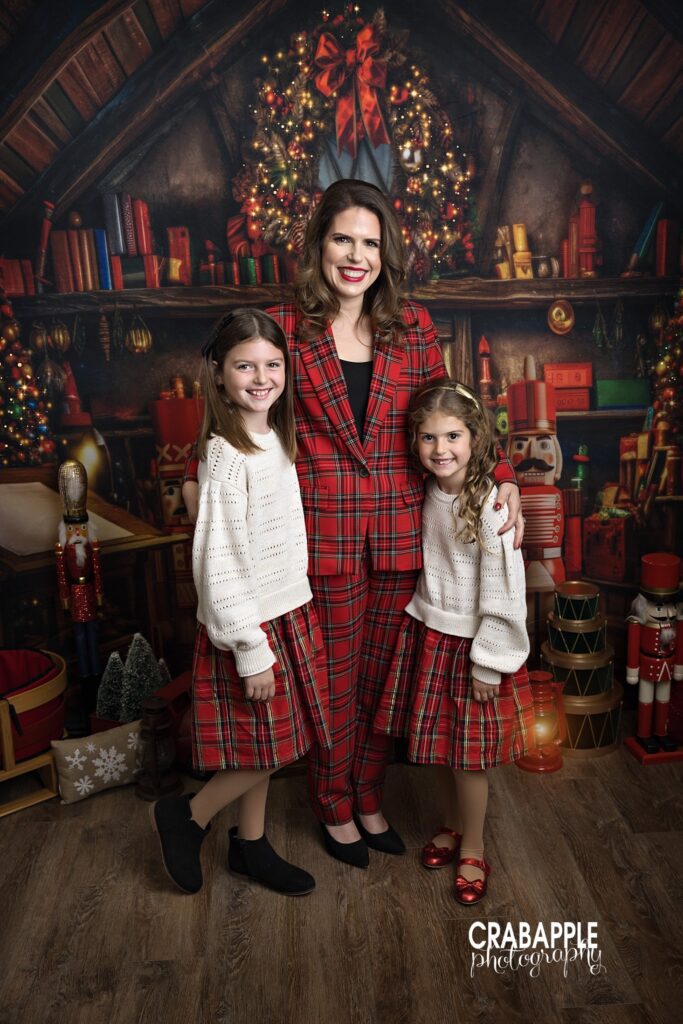 Mom and two daughters in matching red plaid outfits for family Christmas portraits north of Boston