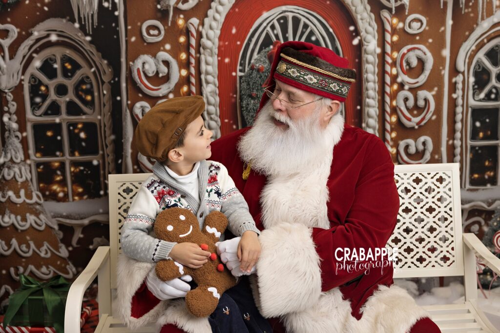 Holiday photos with Santa north of Boston, a young boy tells Santa his Christmas list during portraits with an Andover MA photographer